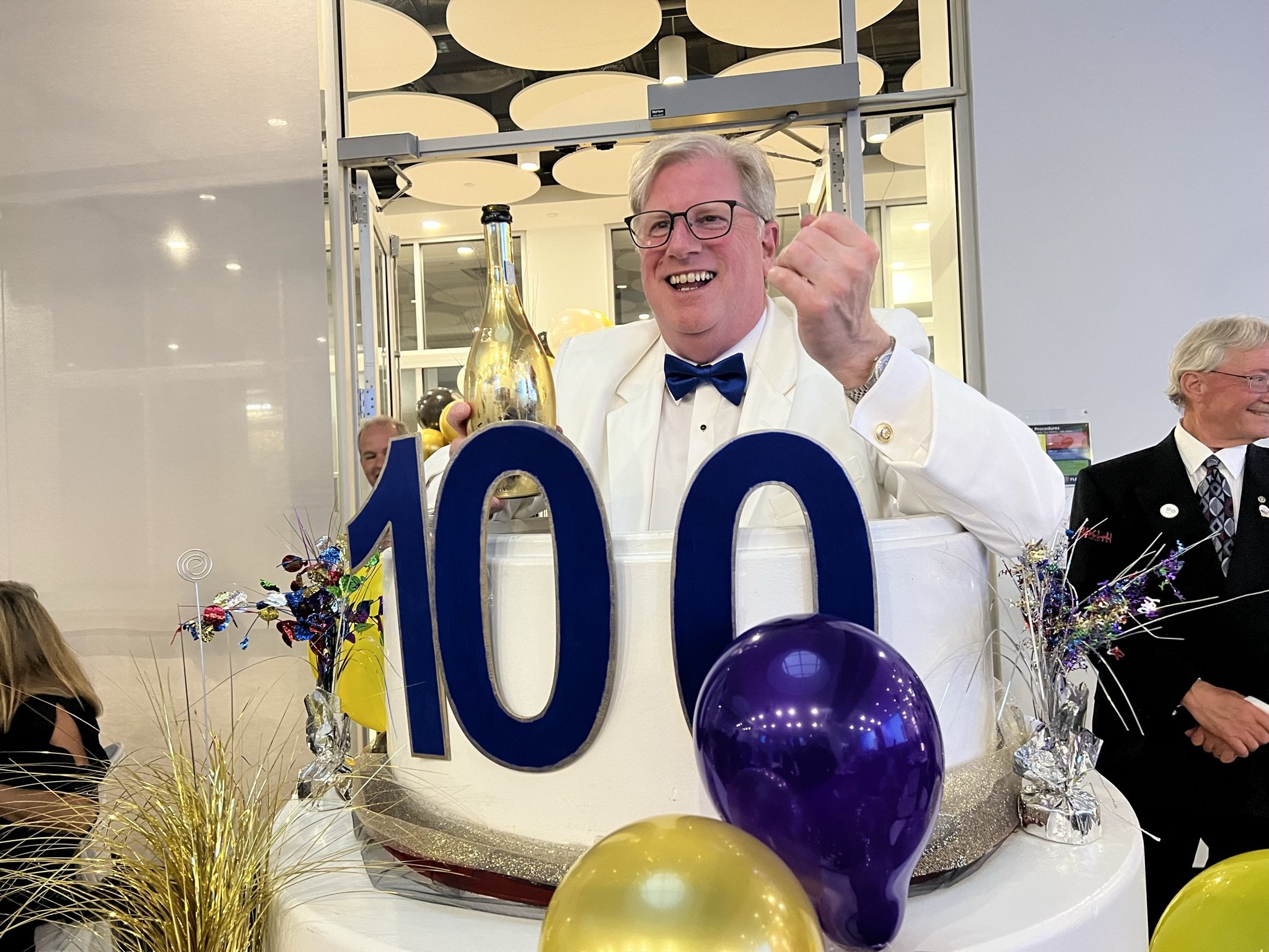  Rotary Club of Peterborough president Wayne Harding (pictured) pops out of a wood cake to mark the club’s 100th anniversary at Fleming College. Photo by David Tuan Bui. 