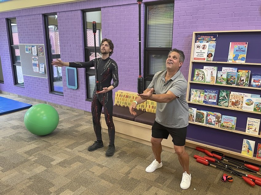  From left, a member of the Peterborough Academy of Circus Arts gives a tutorial in balance to one of the guests attending the event. Photo courtesy of Five Counties Kids. 