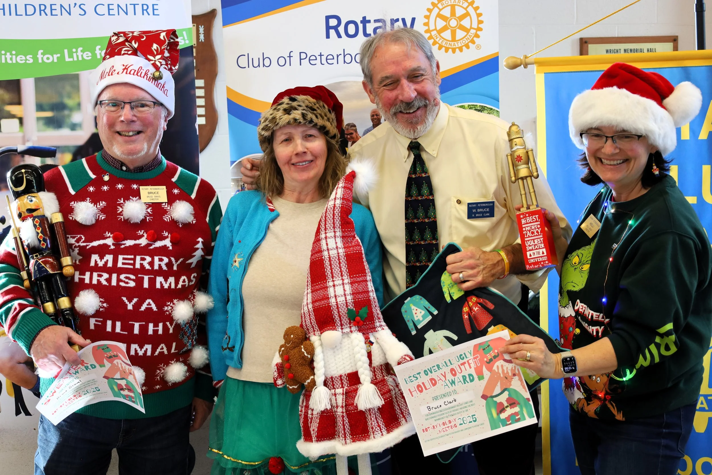 Bruce Gravel, Marie Press and Bruce Clark as the respective winners of the Ugly Christmas Sweater Contest with Kelli Grady, Rotary director of club service and membership. All photos by David Bui.