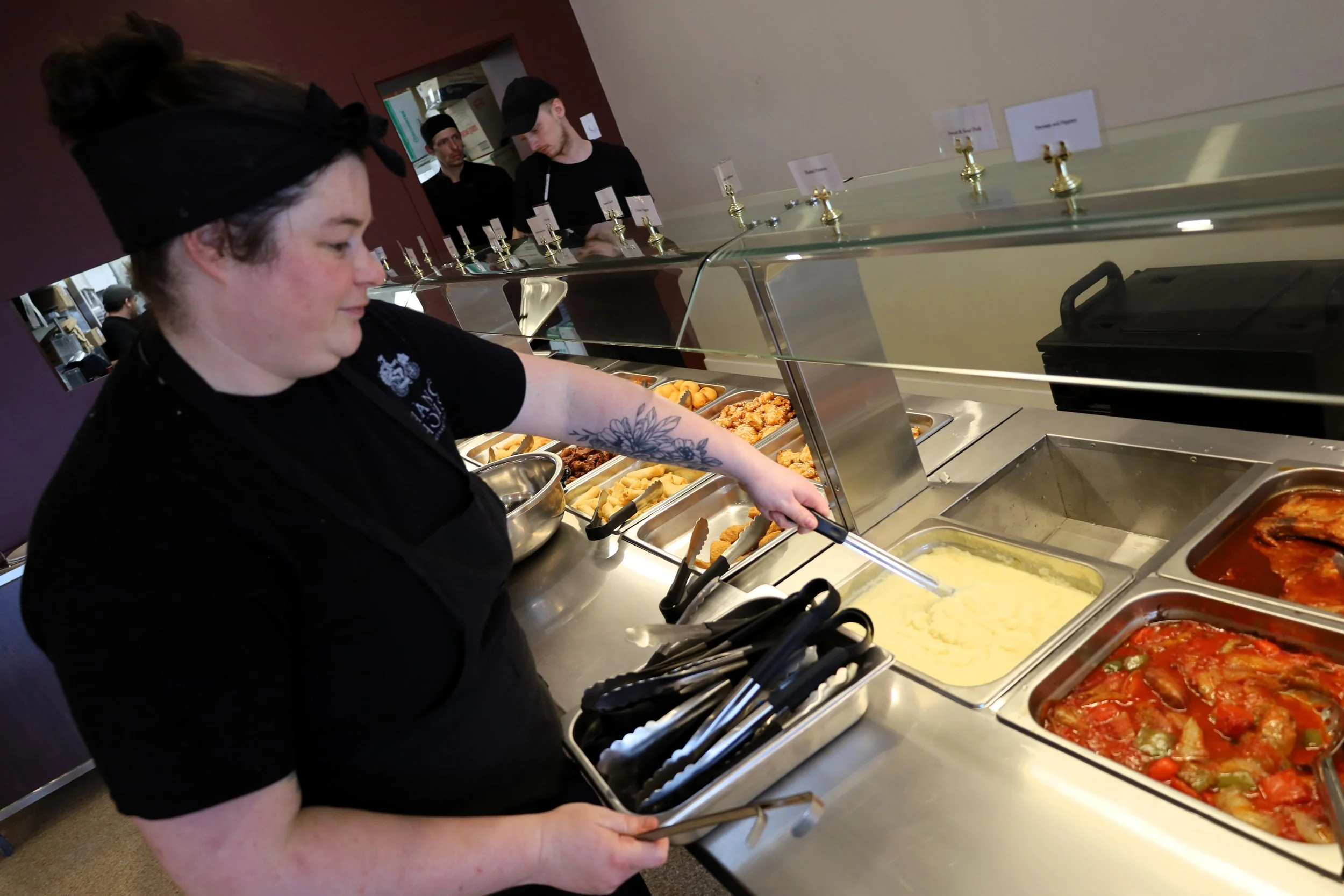 Bell (pictured) sets up all the buffet trays minutes before doors open at the grand opening. All photos by David Tuan Bui.