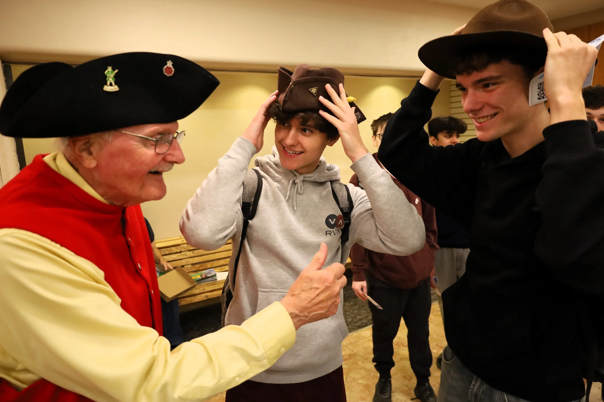 Ken Spry of the United Empire Loyalists' Association of Canada shows off hats worn in the late 1700s to Grade 11 TASSS students Johnny Vanderkolk and Caden O'Brien. All photos by David Tuan Bui.