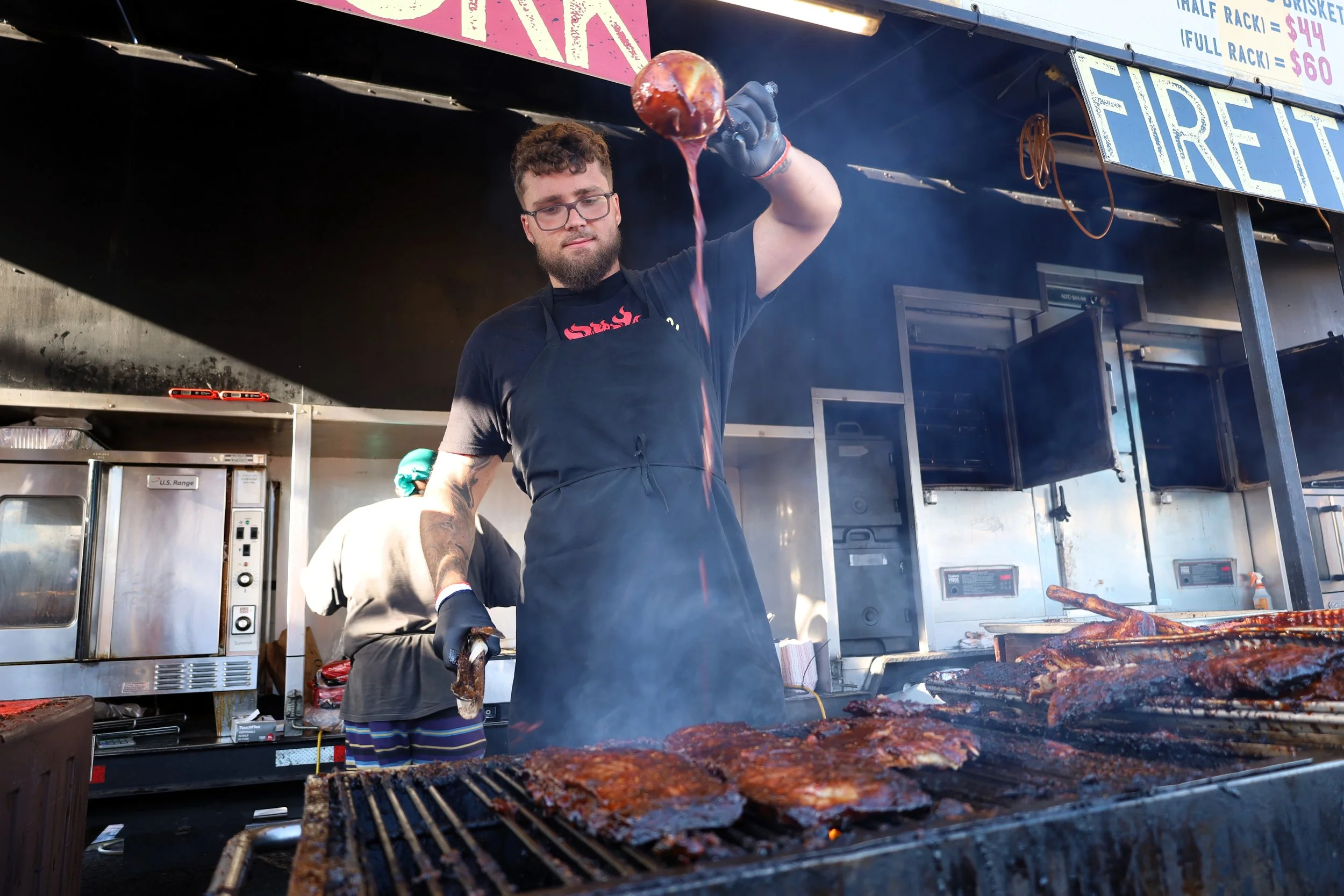 Oscar Pensa, Jack the Ribber manager, slathers some sauce over pork ribs on Ribfest's opening day. All photos by David Tuan Bui.