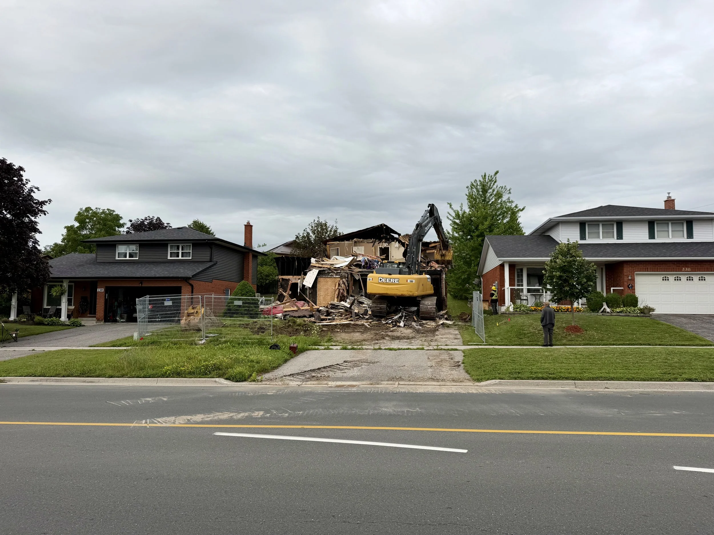 Demolition equipment works through the remains of the Woodglade Boulevard home Monday morning. (Photo by Scott Arnold)