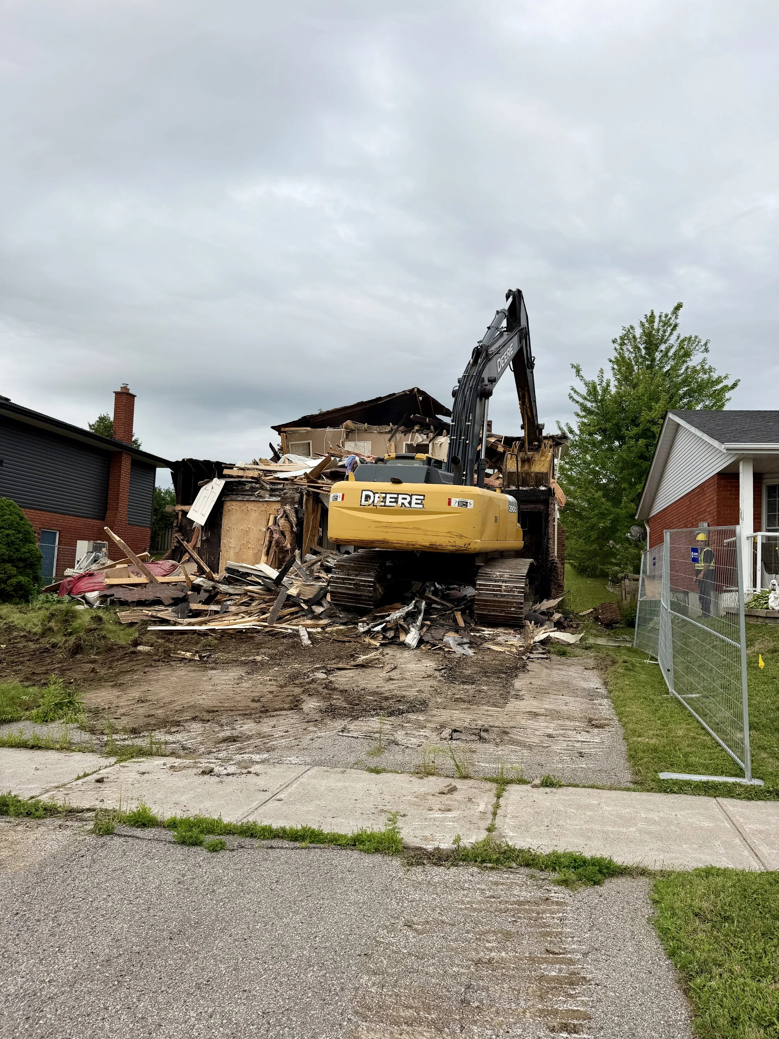 An excavator reaches into the damaged structure as demolition continues on Woodglade Boulevard. (Photo by Scott Arnold)