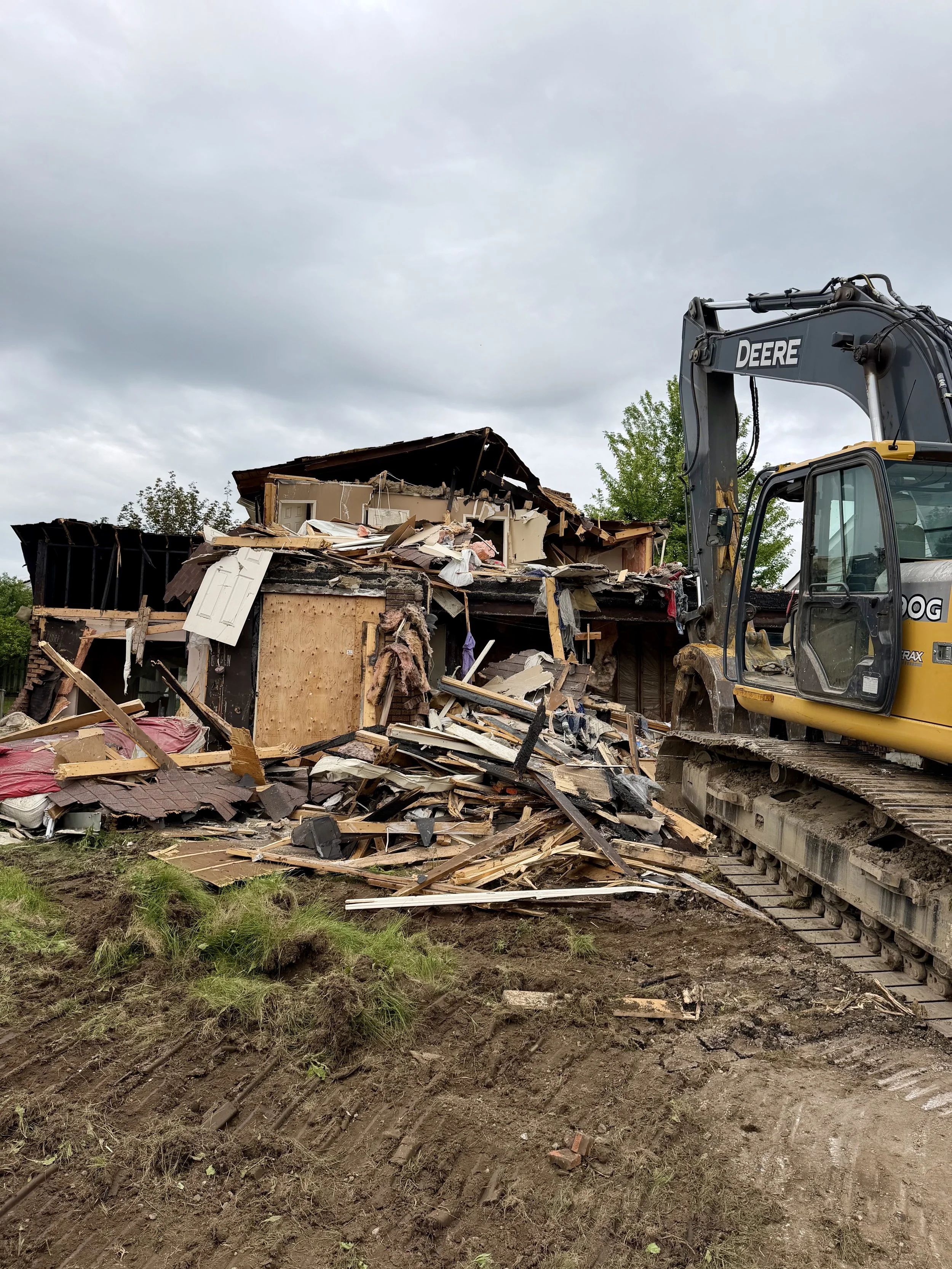 An excavator takes apart the Woodglade Boulevard home nearly four years after it was heavily damaged by fire. (Photo by Scott Arnold)