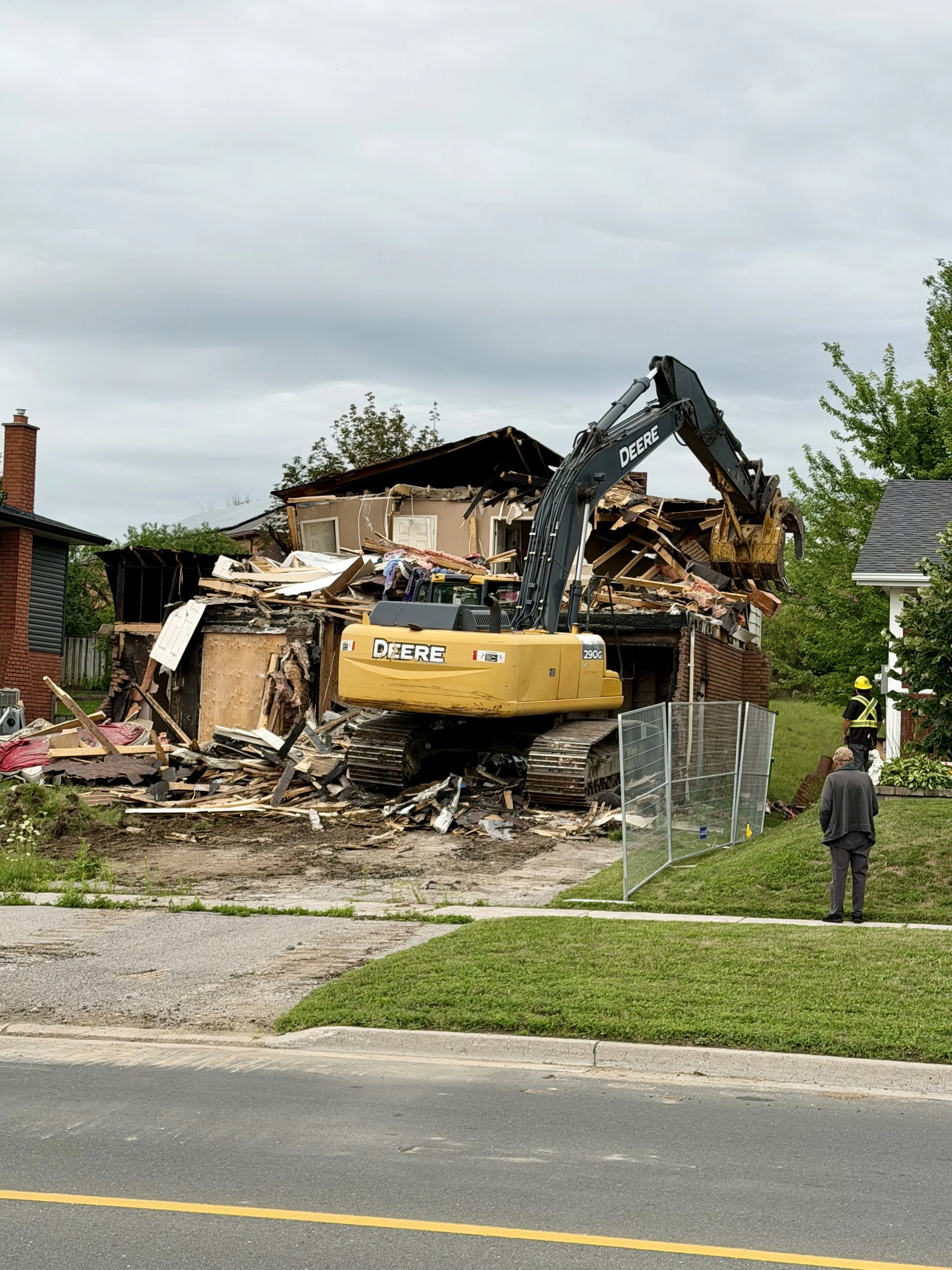 The long-awaited demolition of the Woodglade Boulevard home is underway, with an excavator working through the structure. (Photo by Scott Arnold)