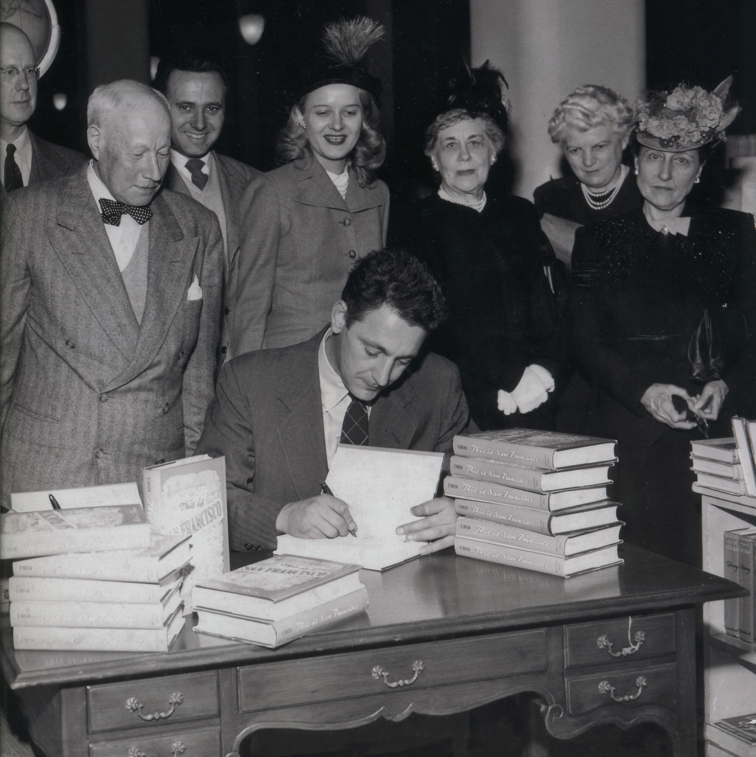 Robert O'Brien signing his book This Is San Francisco , circa 1950. Check out the hats—the ladies LOVED feathers!