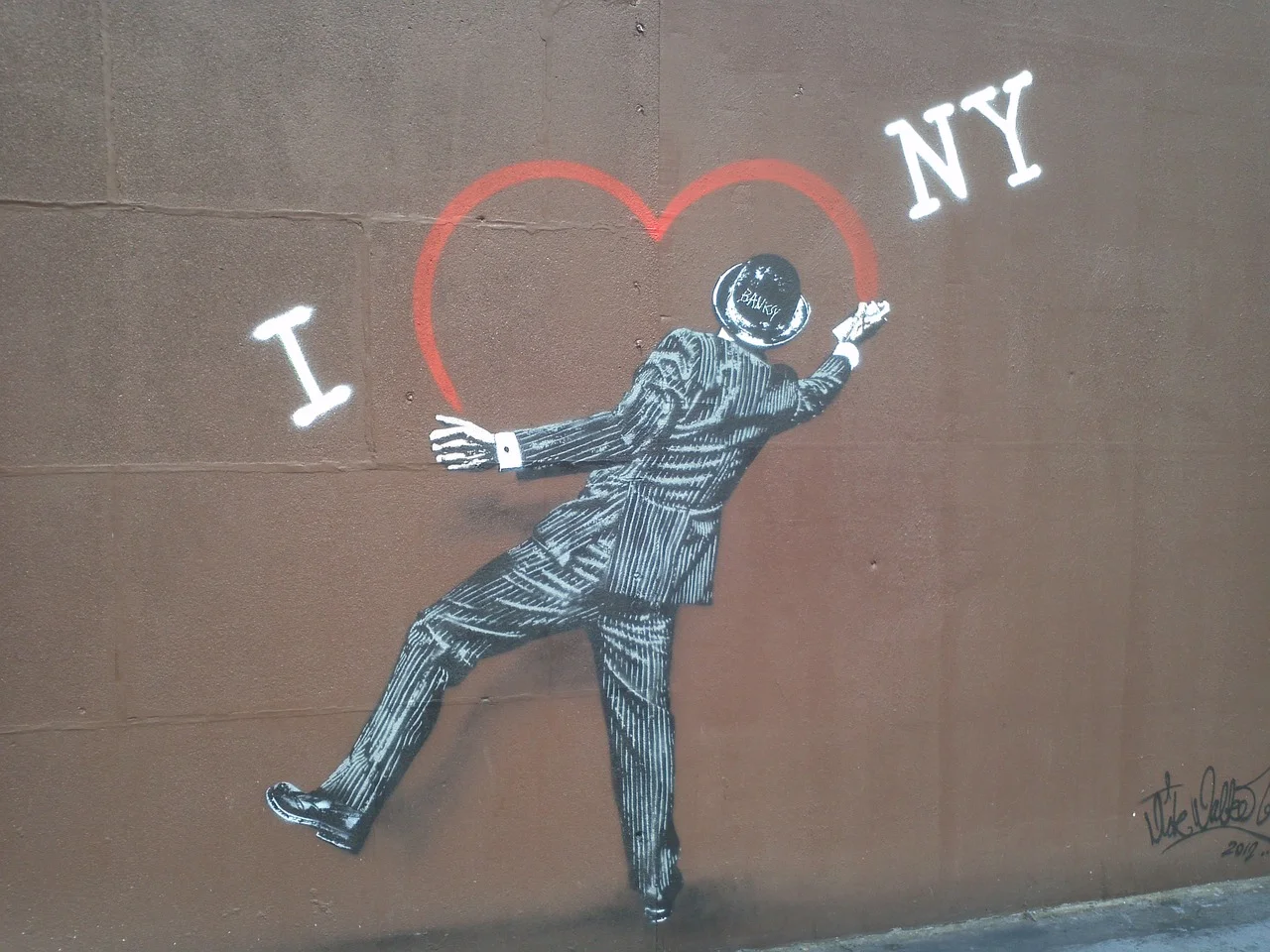 new Banksy off Delancey or new artist “doing a Banksy”? (the later is actually cooler in my mind) there is a “Banksy” signature on the hat that seems very out of place for the original artist and another signature in the lowe…