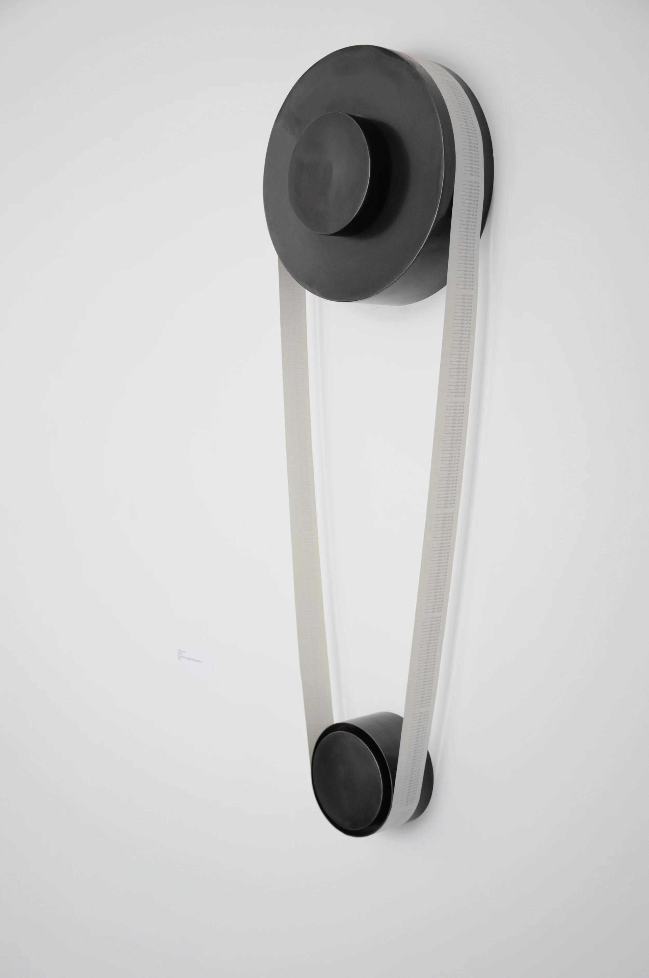   Interval.  12”x 32”. Fabricated steel, found adding machine tape, ink.  Interval  is a moment in time selected and removed from the whole, the time continuum ( Countdown ) and placed on a pedestal reminiscent of gears. This piece is about how we is