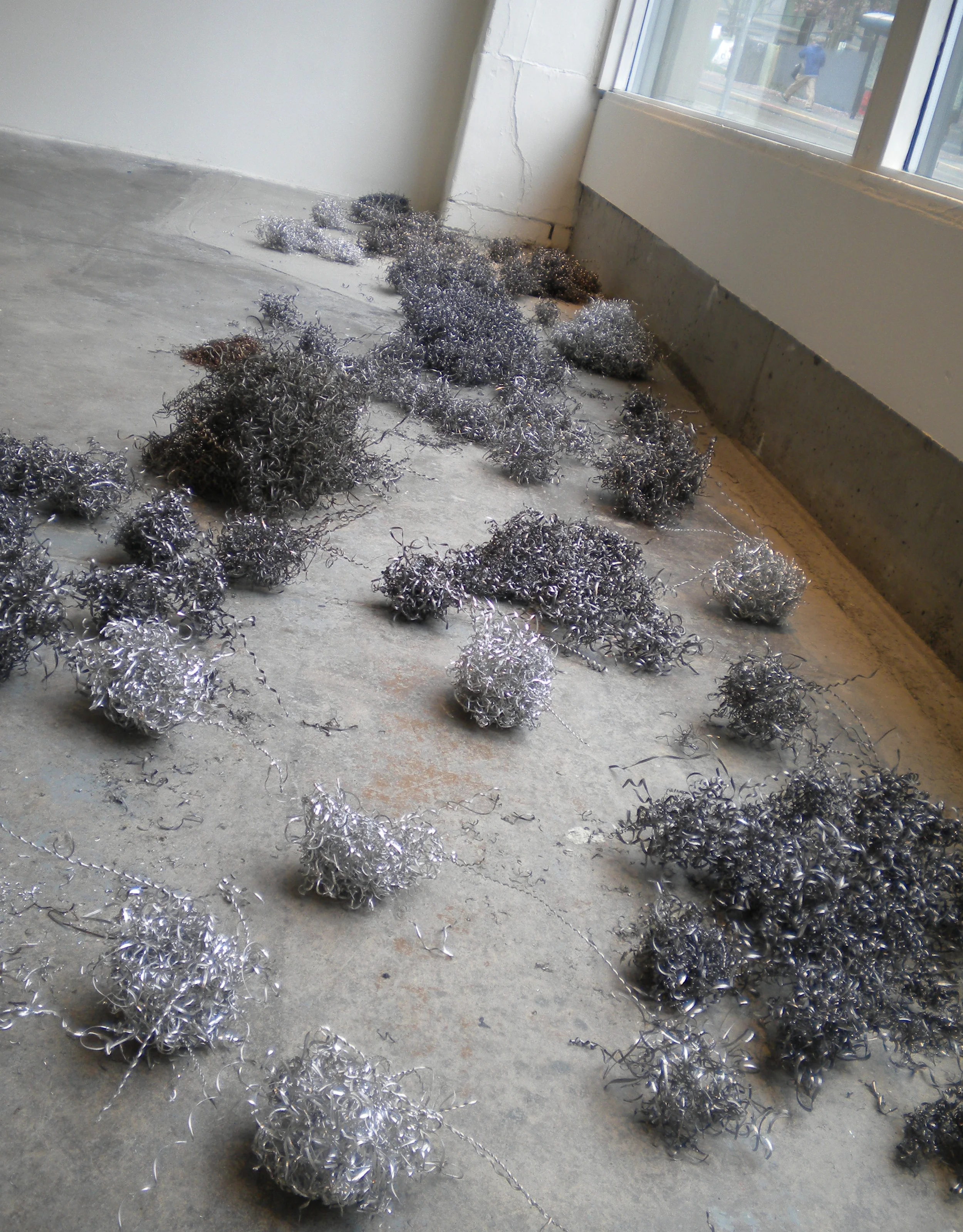   Filings.  4”x 20’.  Steel and aluminum filings leftover from the drilling process. Installation view. 