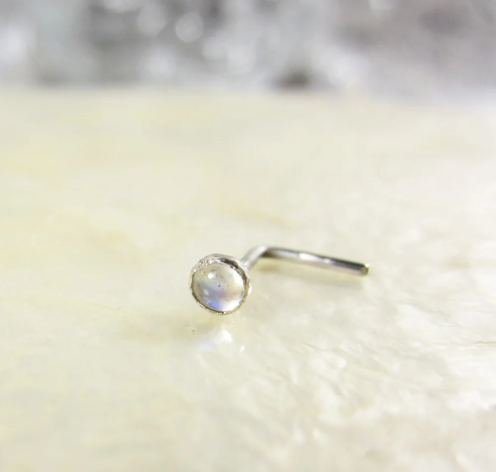 Tiny 3mm genuine Moonstone in a nose stud you can wear every day. All my nose studs are finished to smooth perfection so they are comfortable to wear. If you love this style but prefer another colour, that's no problem. Below you will find a list of colour options to choose from. All the colour options are genuine gemstones. 5mm x 5mm L-shape post in 20g sterling wire. Purchase here Black - Spinel Blue - Sapphire Brown - Garnet Green - Peridot Gray - Moonstone Orange - Spessartite Garnet Pink - Tourmaline Purple - Amethyst Red - Riby White - Pearl Yellow - Citrine
