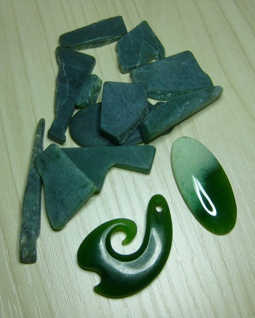 From the vault: a small pile of rough Greenstone that was given to me several years ago and my recently acquired pieces from the antique shop: a Matau and an oval cabochon.
