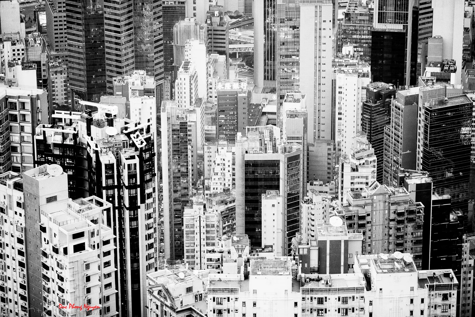 A black and white aerial view of a densely packed city with many tall skyscrapers and buildings.