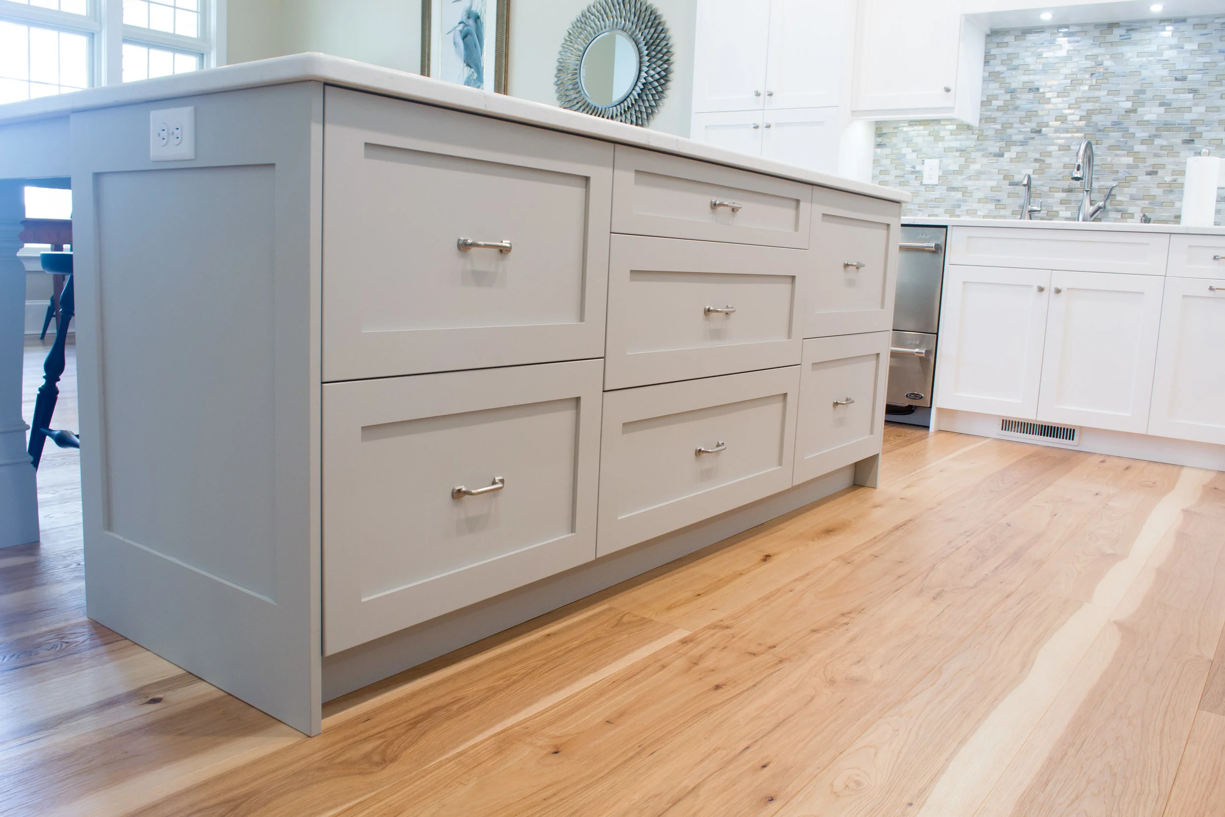 White painted kitchen with a grey island deep drawers and hidden organization