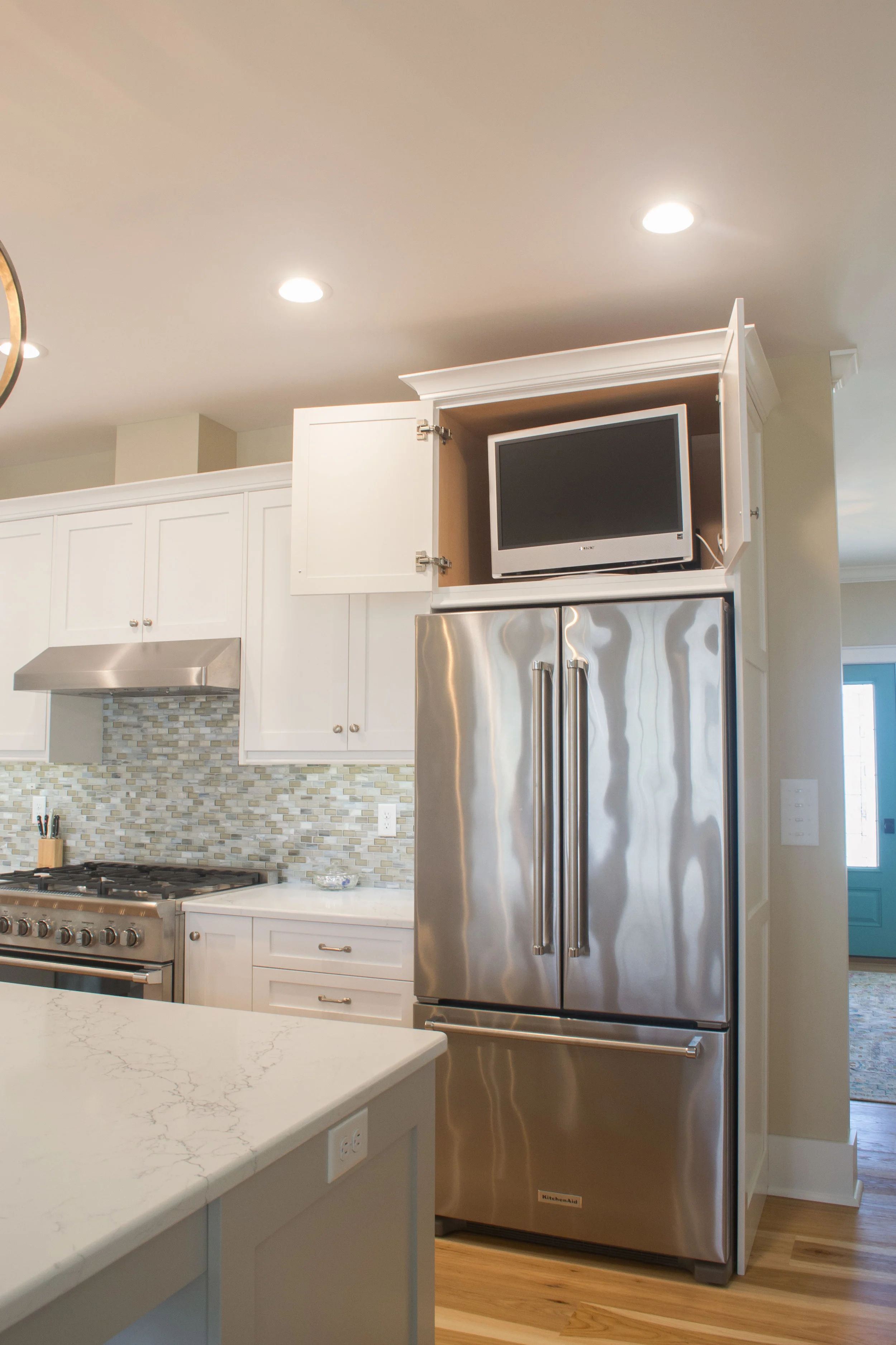 White painted kitchen with a hidden t.v. cabinet