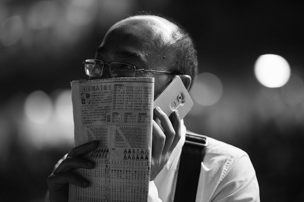 A man is considering a bet at the Hong Kong Jockey Club