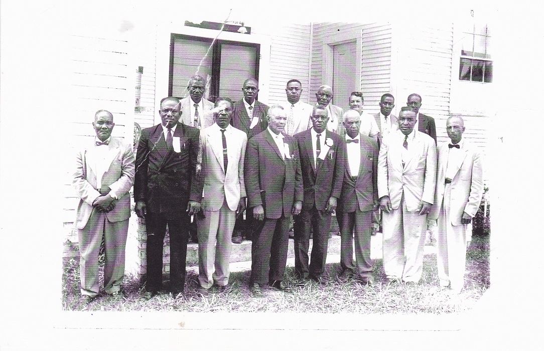 Pastors, Officers, & Ministers of the East Carroll Baptist Association, late 1950s standing in front of North Star Baptist Church, pastored by my father & main character in Witness to the Truth." Back Row, left to right: Rev. Newson, Percy Knighten, Rev. Francis J. Atlas, Rev. Handy Jackson, Genevieve Shorter (Treasurer and first female elected to hold this position in 1953), R. B. Stevenson, Rev. N. B. McCall. Front Row, left to right: Rev. Spencer Hall, Rev. Freddie Green, Rev. J. H. Moore, Rev. Mansel Mason, Rev. O. L. Virgil, Rev. H. T. James, Rev. Percy H. Henderson, Rev. John H. Scott (President)