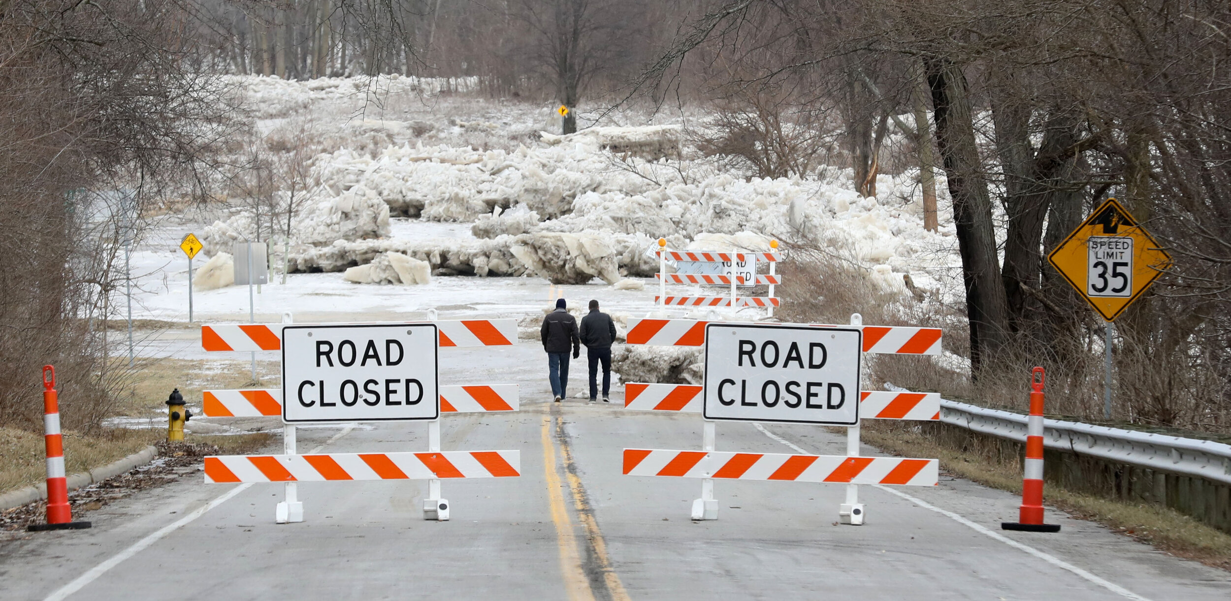  Nolan Foster, left, and his father-in-law Tim Kohler walk down River Road in Maumee to view the ice formations that caused the road to close. The flooding of the Maumee River, followed by freezing temperatures, caused gigantic chunks of ice to block