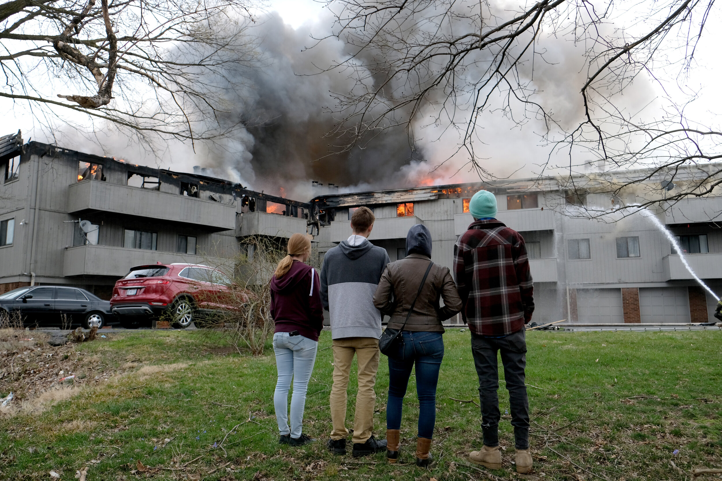  Bystanders watch as the Toledo Fire Department fights an apartment fire at 5900 block Cresthaven Lane in Toledo. © Toledo Blade | March 2021 