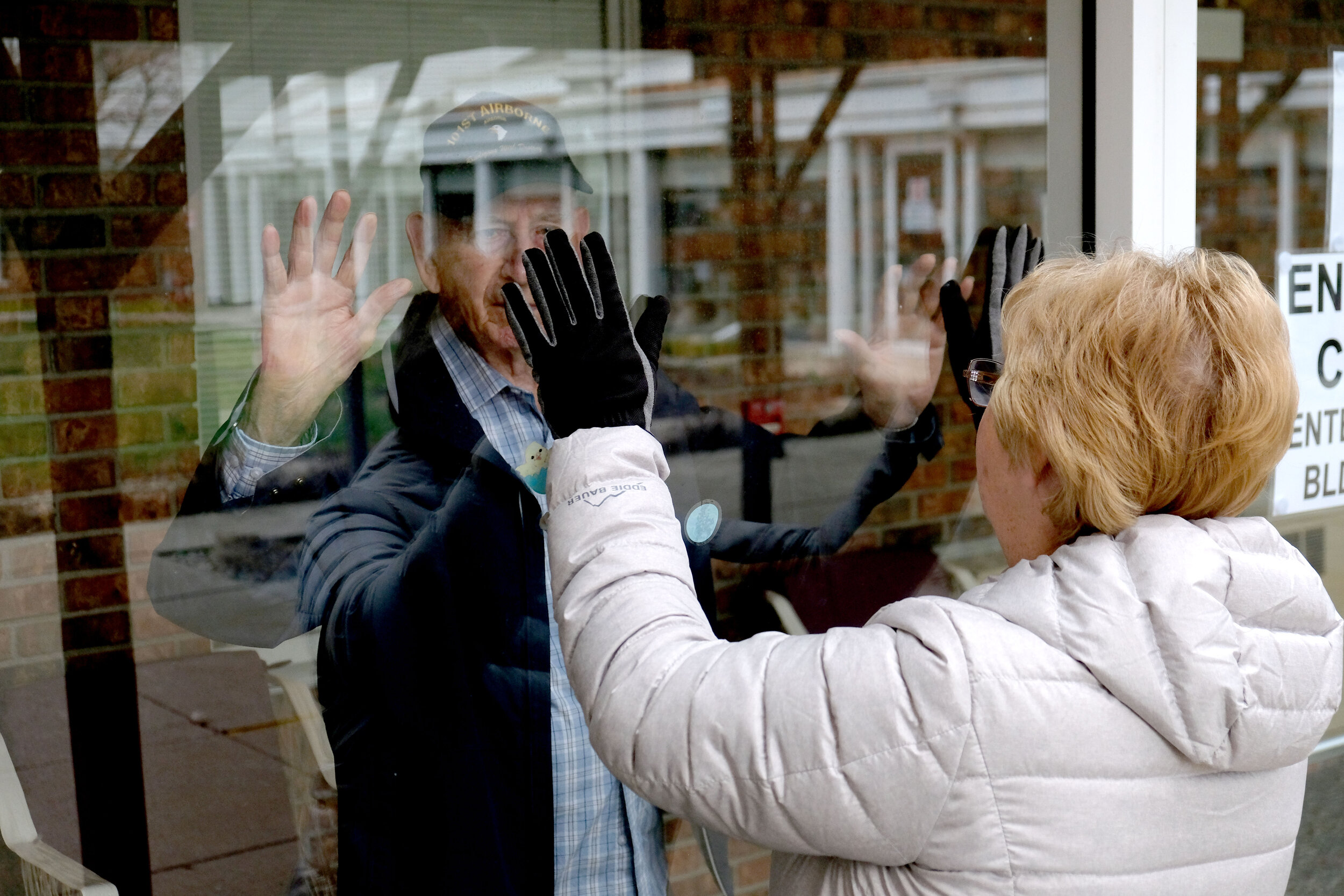  Due to covid precautions, World War II veteran and Purple Heart recipient Jessie Petree, 89, is only allowed to greet his daughter Sherri Fischer through a window at the Elizabeth Scott Community in Maumee, Ohio.  © Toledo Blade | April 2020 