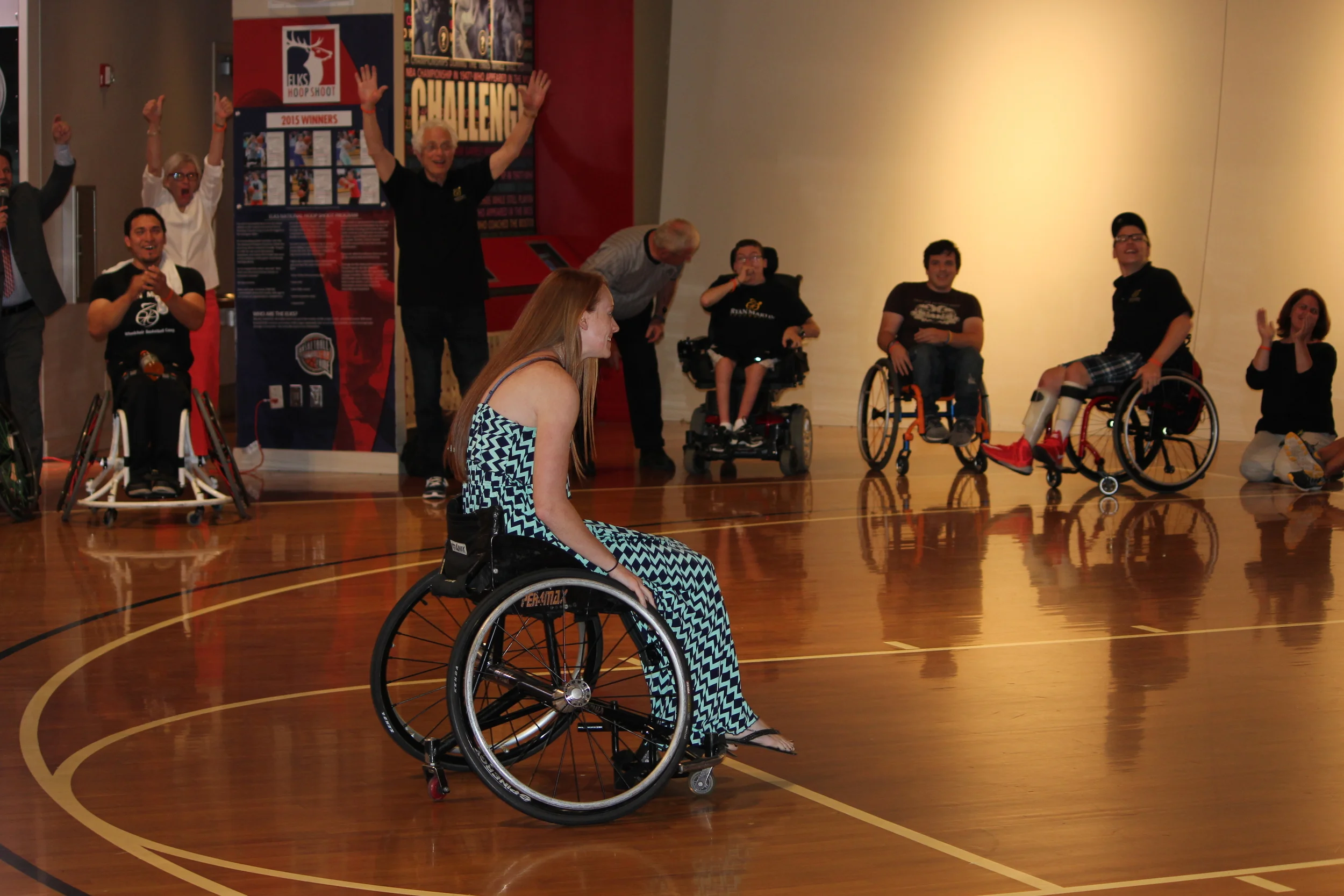 Lucky Lindsay Feducia makes the basket shooting from a chair, to win the $1000. prize, at the 2015 Hall of Fame Exhibition game.