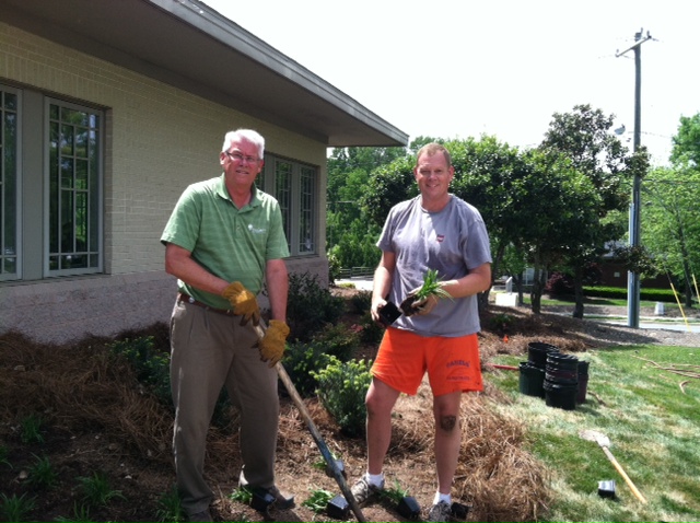  Gary Upchurch from New Garden Landscaping &amp; Nursery works with a volunteer to plant the memorial garden. 