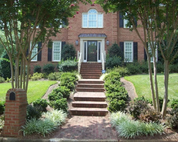 Six months after renovation. Picture taken in August. Plants are Carissa holly (along walkway), Ligustrum (foundation) and barberry (under crape myrtles).