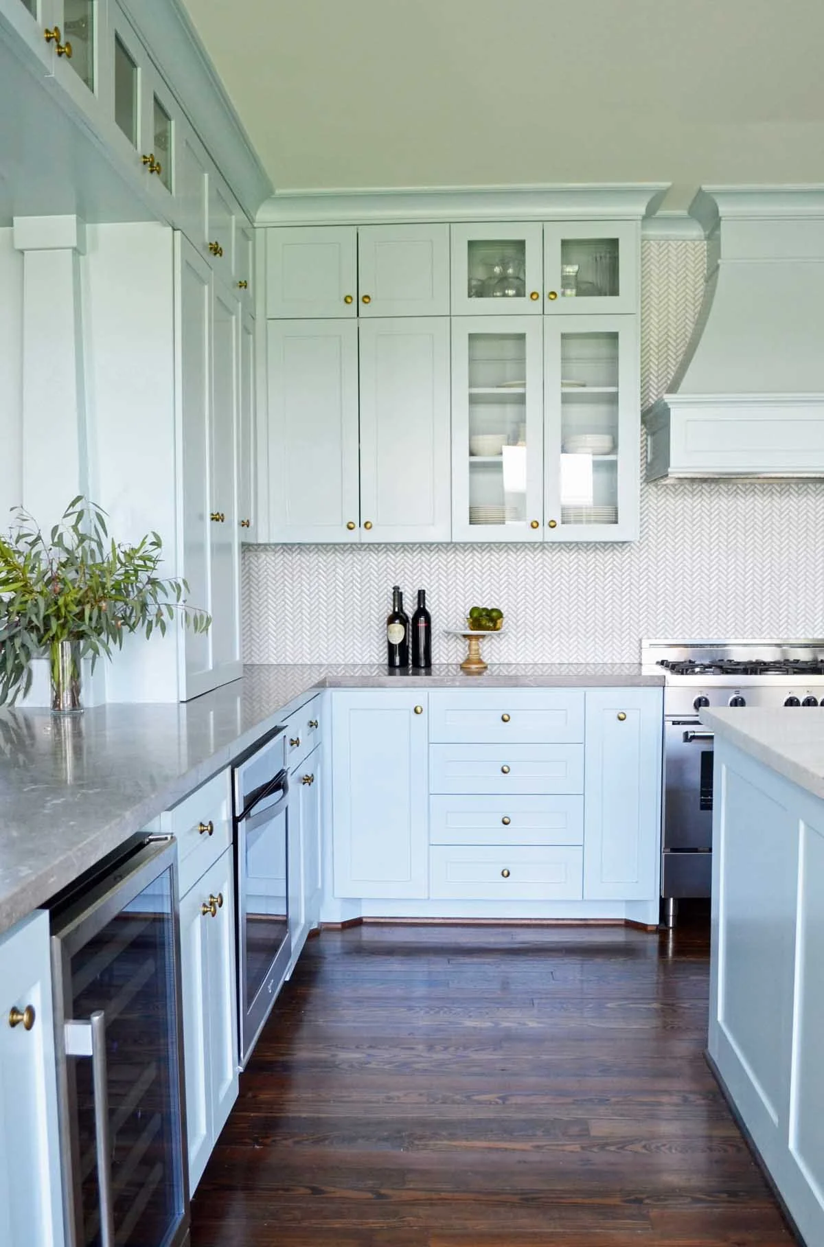 Custom blue kitchen opens to family room with an architectural opening in Denver bunglaow.