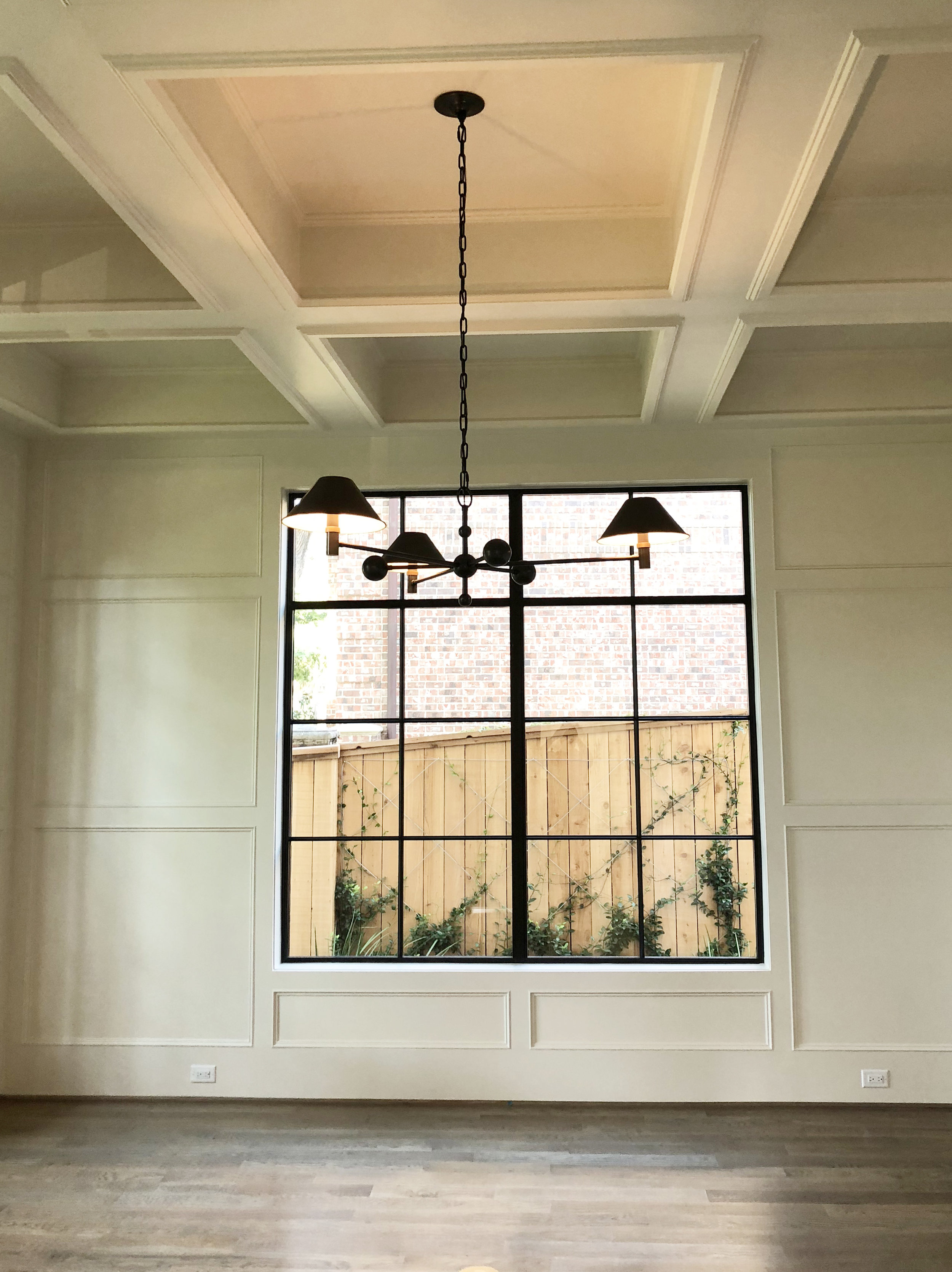 Square paneled study with steel windows and modern light designed by Berlin based interior designer Jamie House of Jamie House Design.