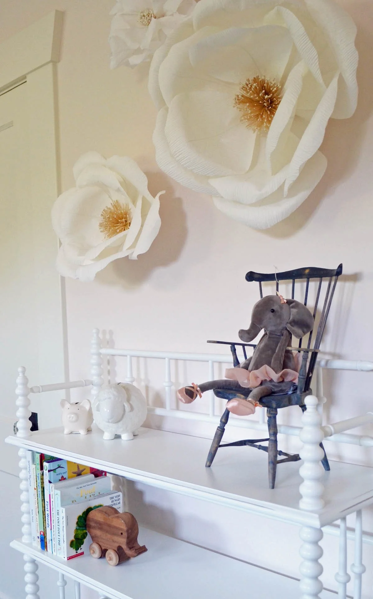 Turned wood shelf with toys in a nursery with flowers on the wall in Denver historic bungalow renovation.