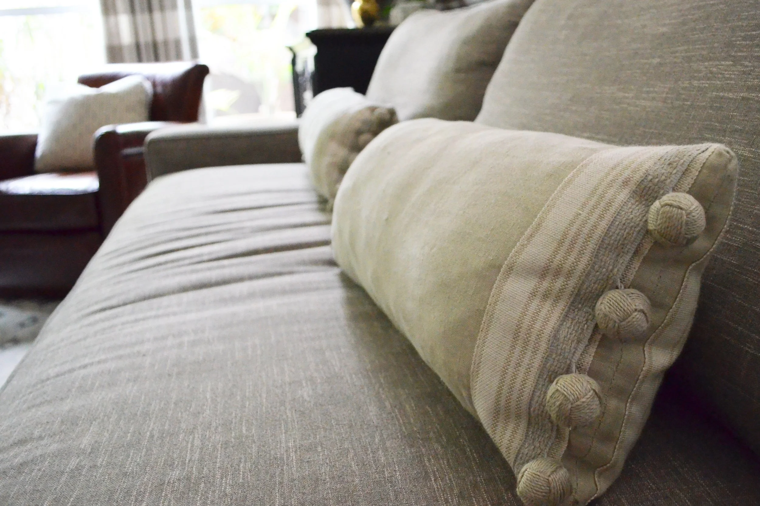 Using a giant trim on sofa lumbar pillows throws the proportion in the design enough to keep it from being boring.