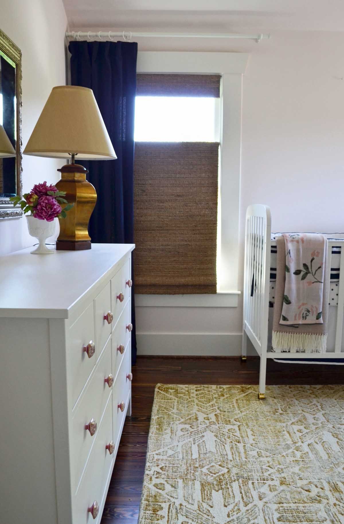 Pink and navy nursery with Ikea dresser and custom knobs in historic Denver renovation
