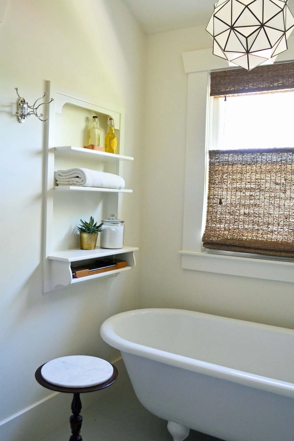 Clawfoot bathtub retreat in historic home renovation using phone niche as wall shelves
