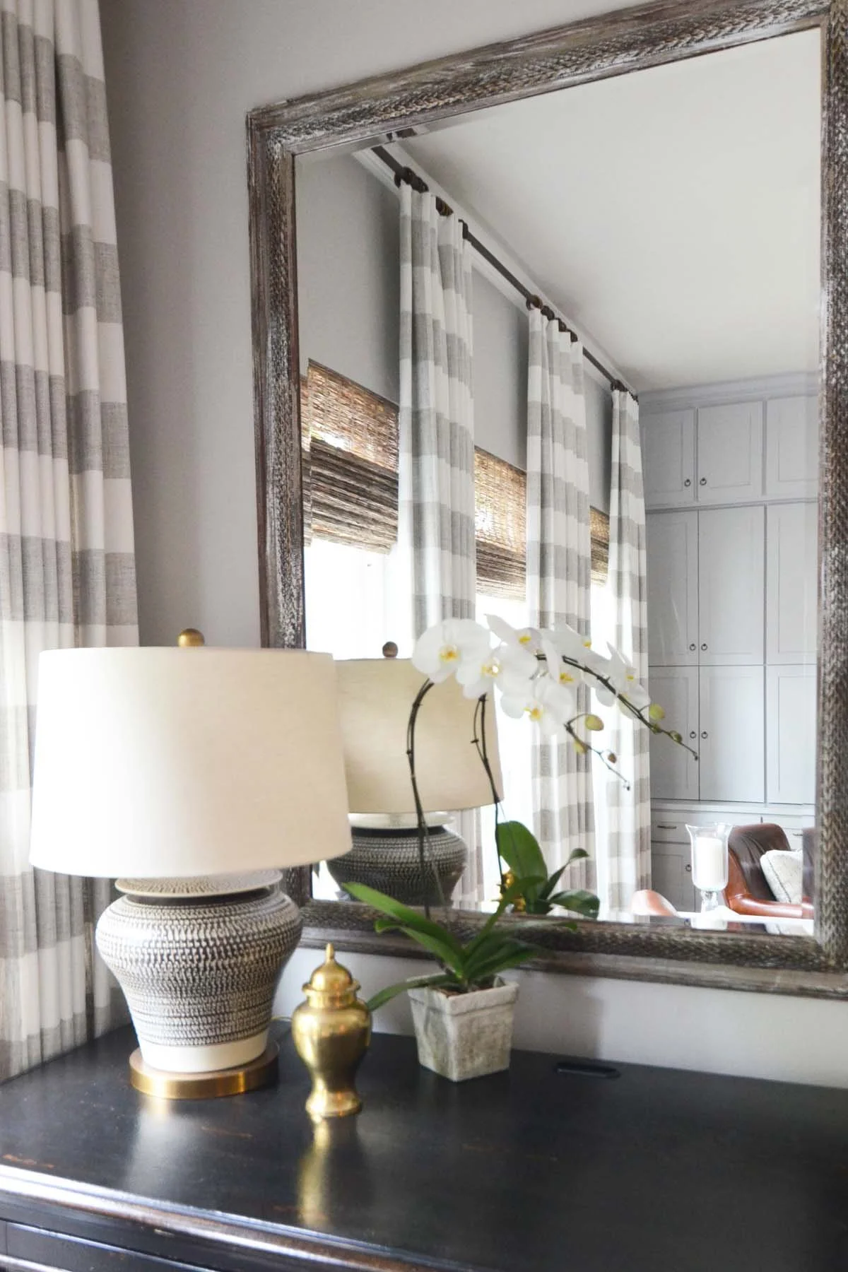 Custom built-ins and draperies reflected in a mirror after full house renovation