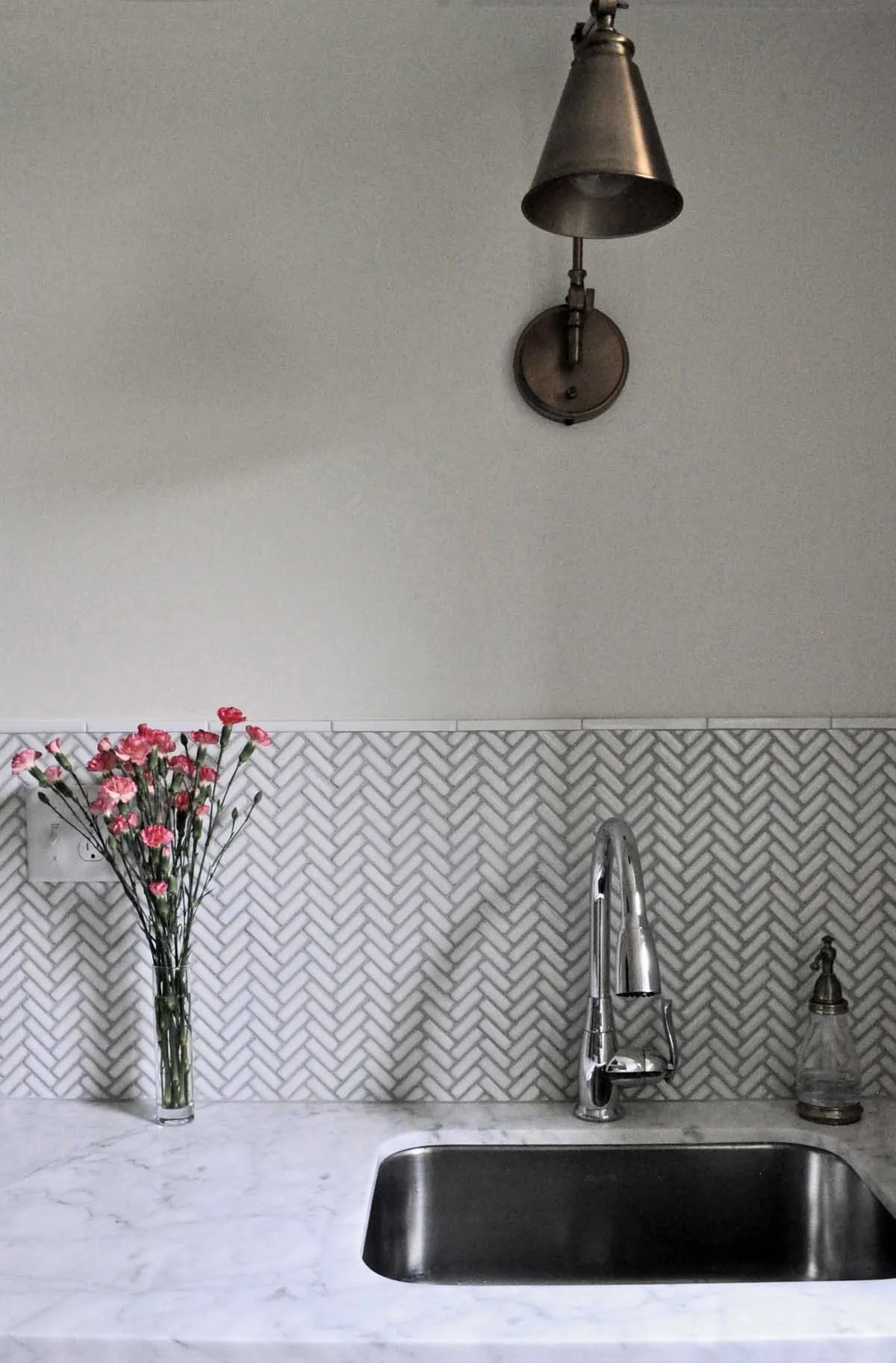 Herringbone tile finishes the laundry sink area in this Denver area historic home renovation