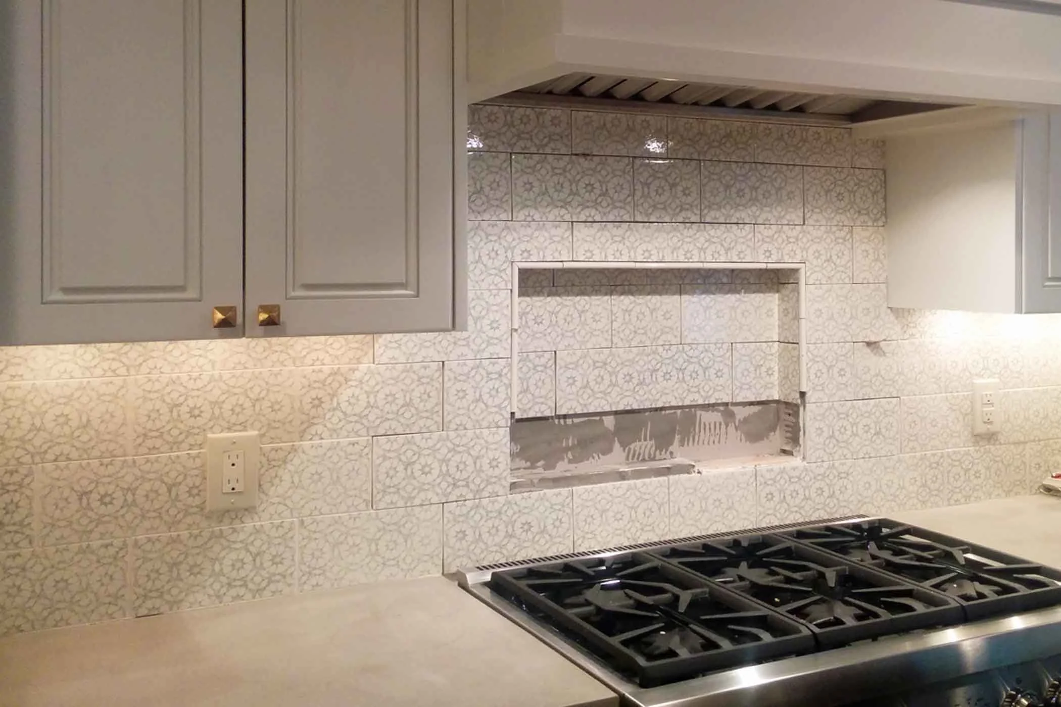 Creative subway tile installation with unexpected grout color and mixed materials in Centennial kitchen