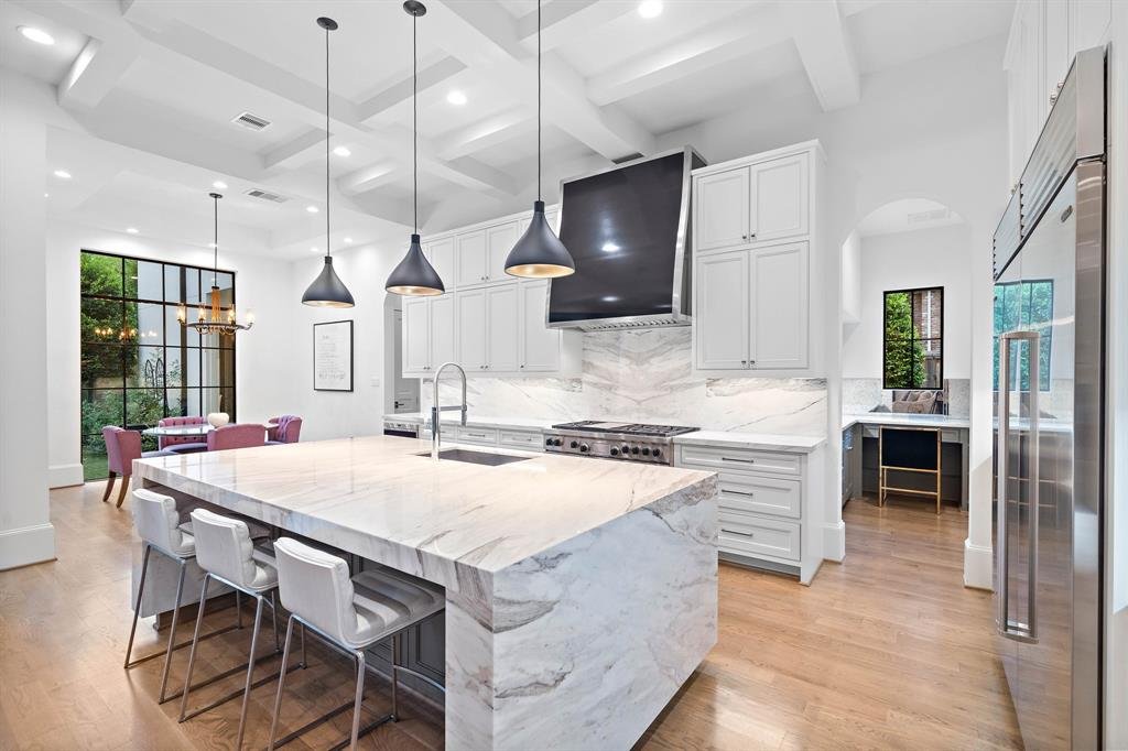 Bookmatched marble slabs on the island and backsplash add to the luxury of this modern kitchen design