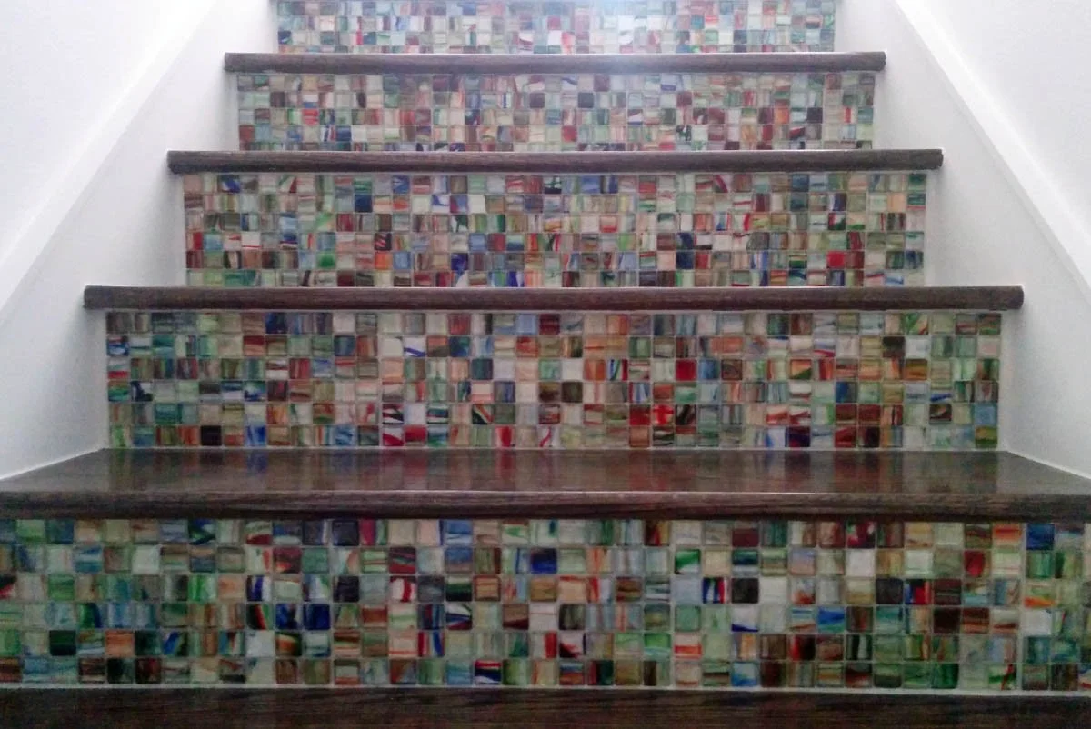 Stairs in a basic builder townhome were personalized with custom mosaic tiles on the risers