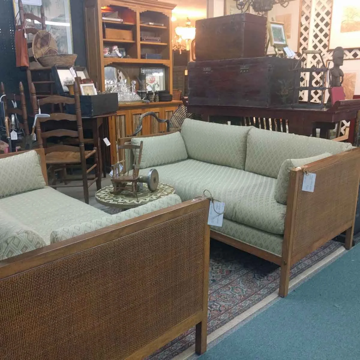 Pair of antique raffia loveseats in a scale rarely found in new furniture, sourced for an engineering offices lobby.