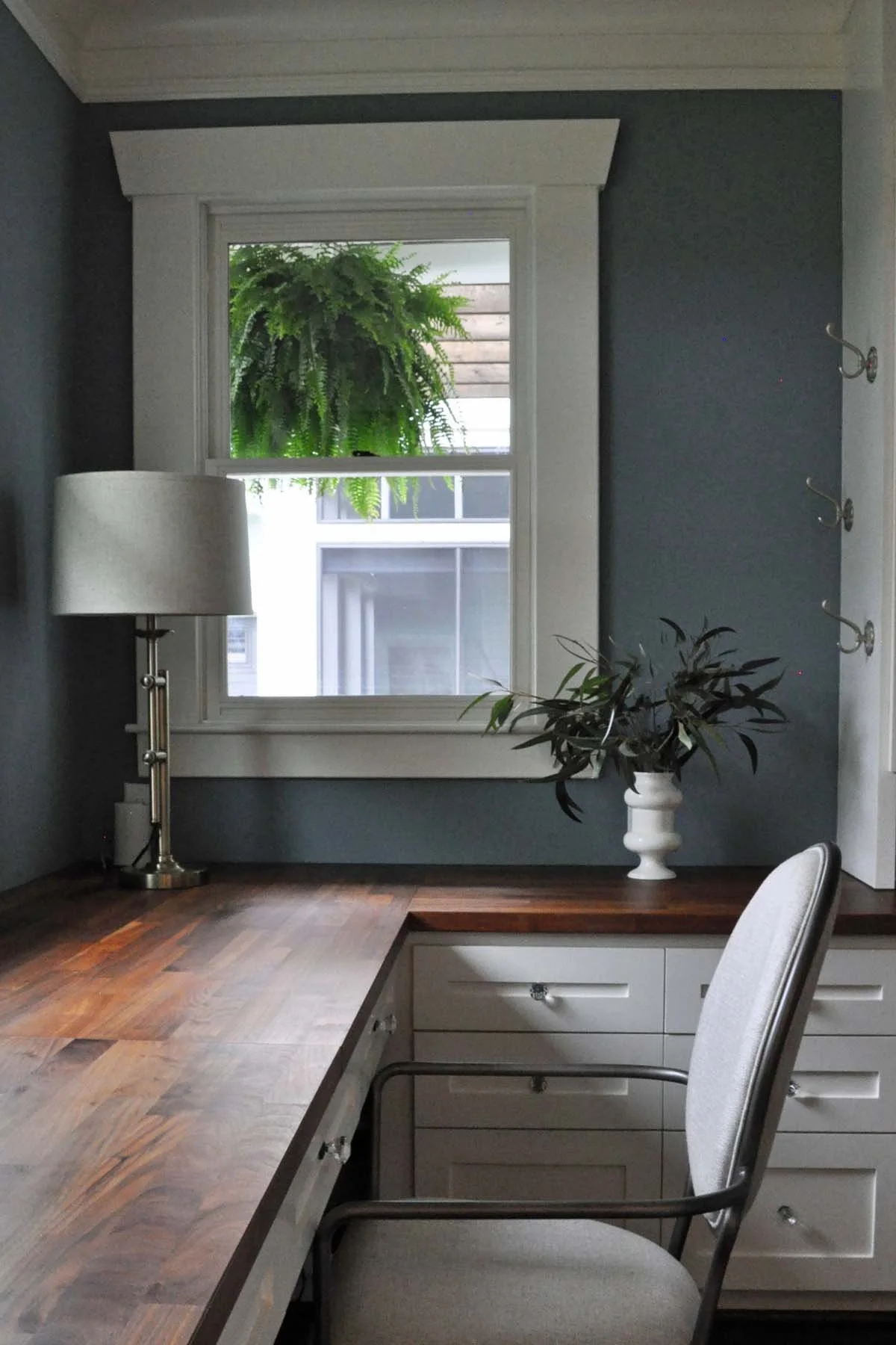 Custom built-in desk area fills in a nook adjacent to the kitchen that is otherwise wasted space.