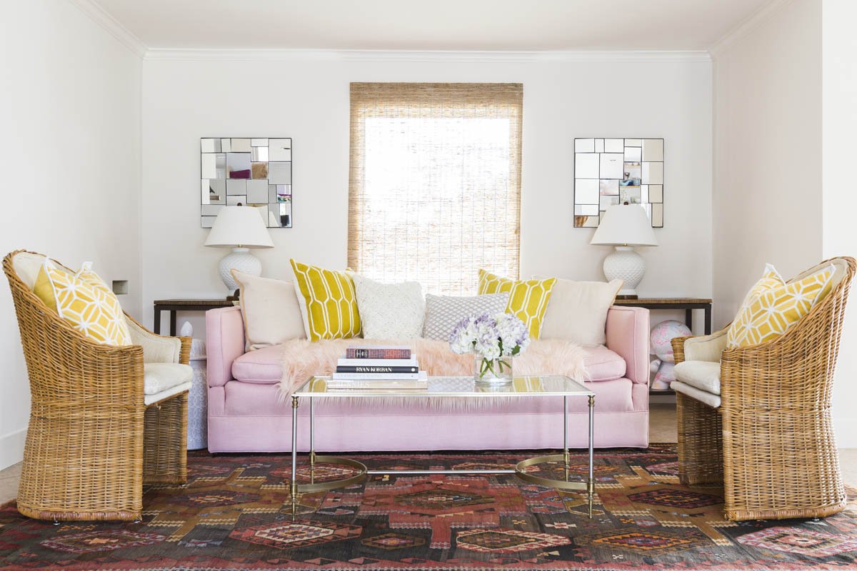 Pink sofa and antique Turkish rug pull together this formal living room in Littleton CO