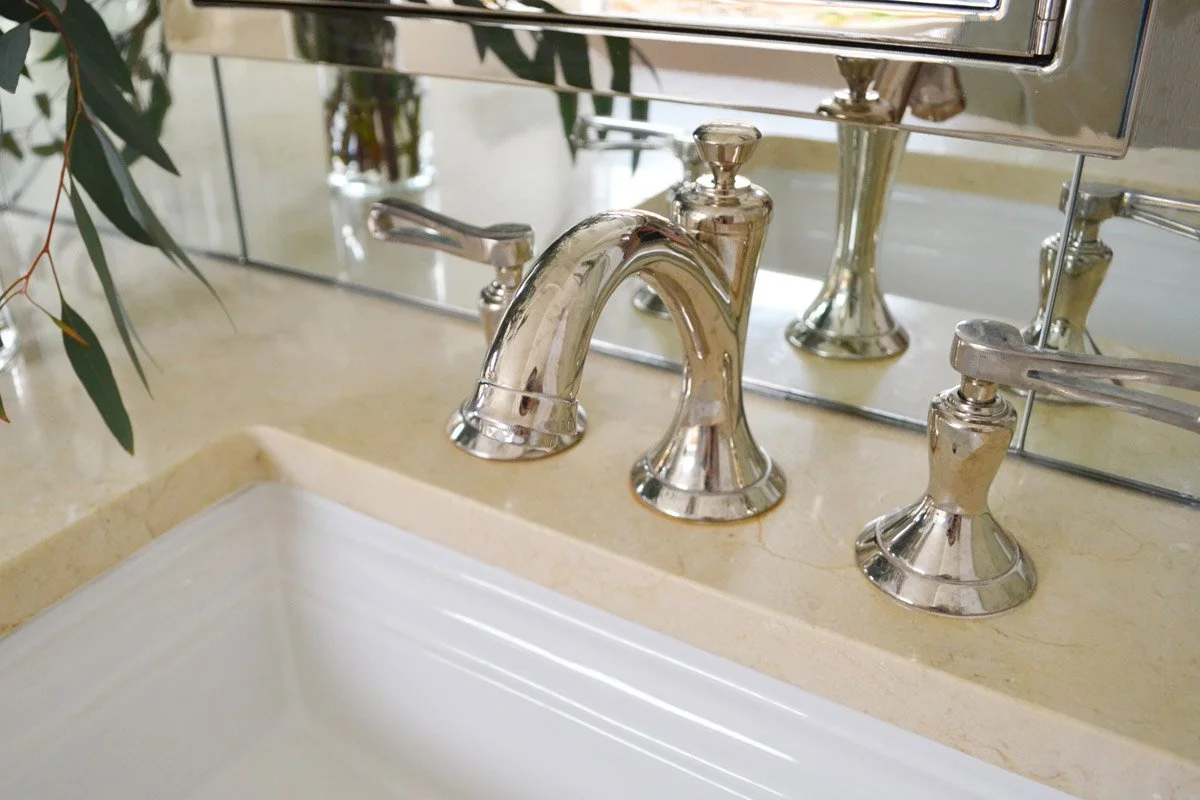 Primary bathroom remodel materials with mirror to the marble counter and polished nickel plumbing