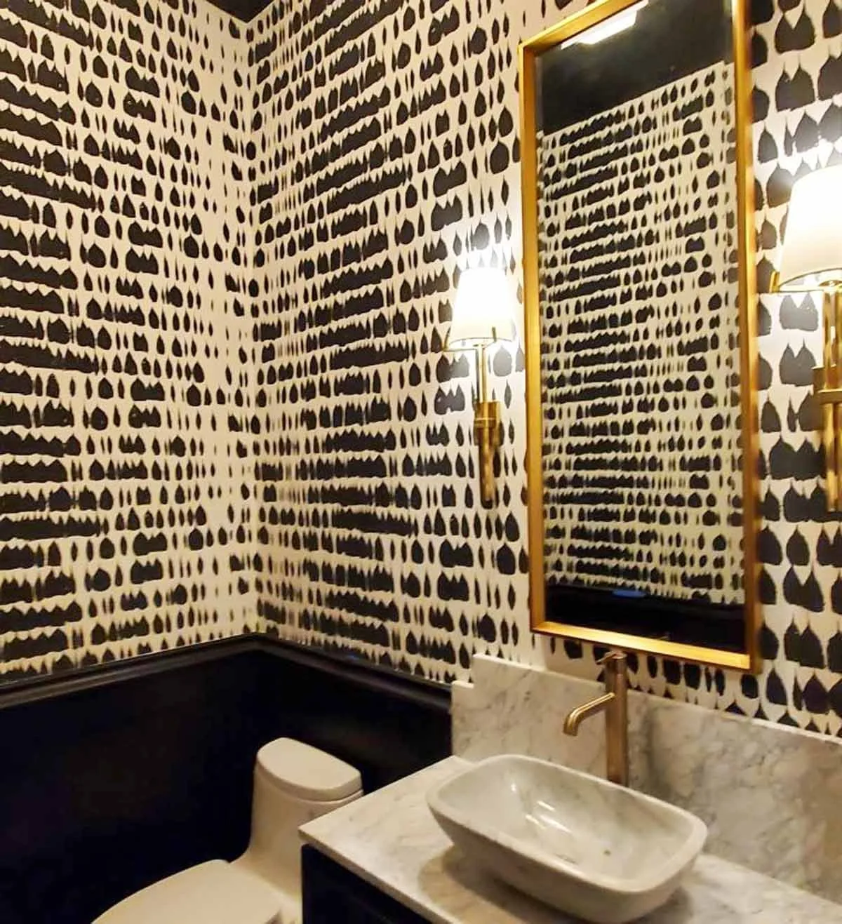 Bold wallpaper and brass accents in a powder room designed for bold clients in Castle Pines CO