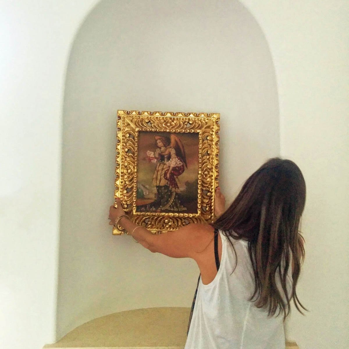 Antique art placement during installation of a Castle Pines remodel by Jamie House Design.