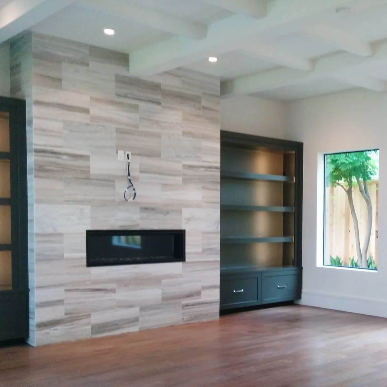 Fireplace wall with custom built-ins being installed after design by Jamie House Design