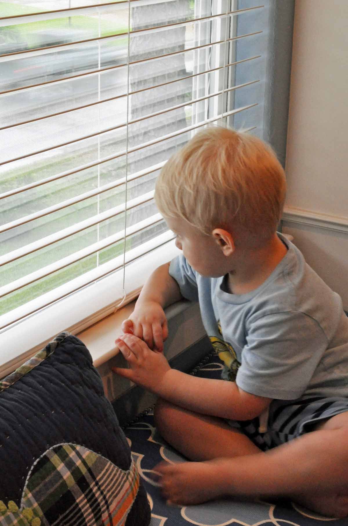 Client enjoying the new built-in window seat and cushions in his bedroom remodel