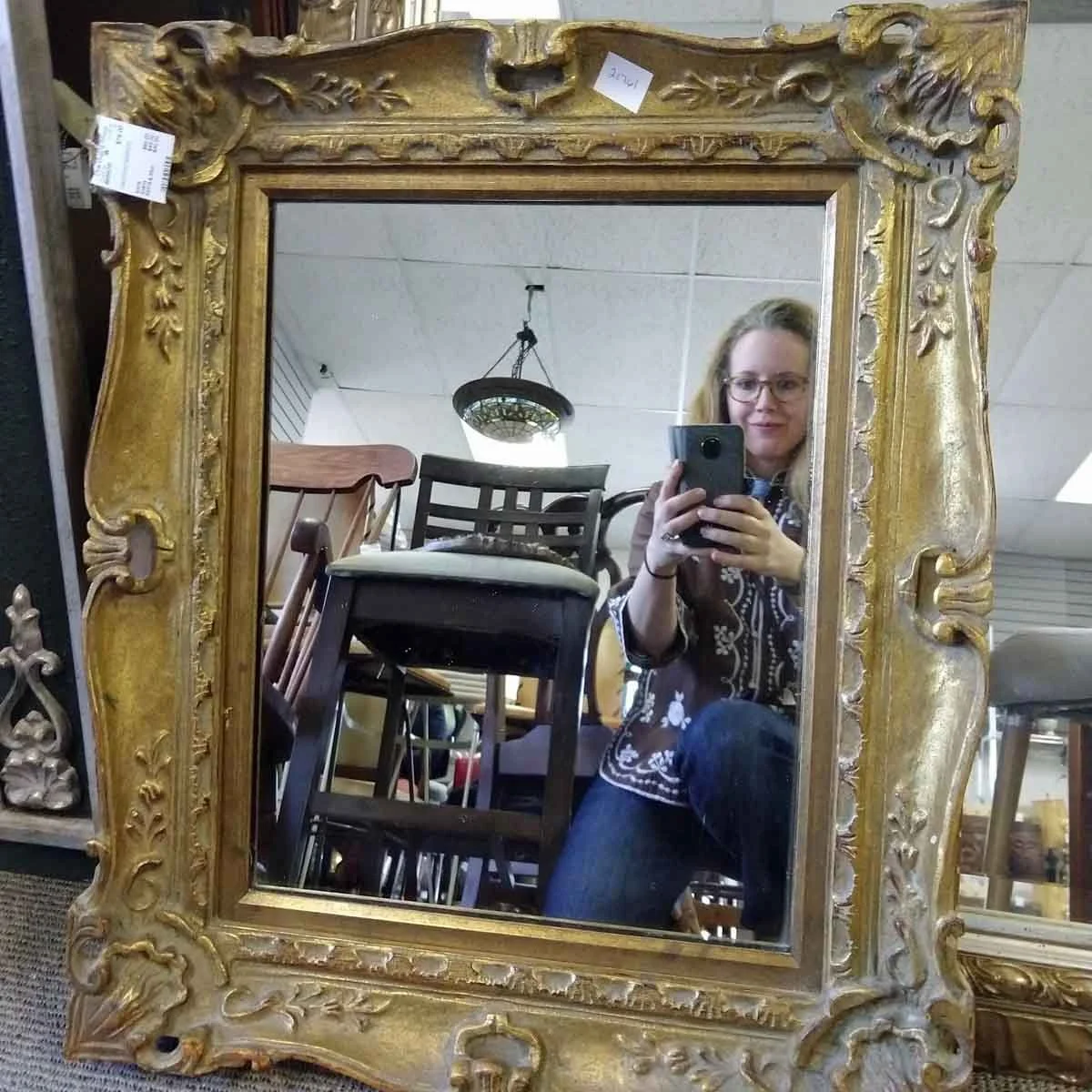 An antique gilded mirror sourced for its intricate detail and timeless character.