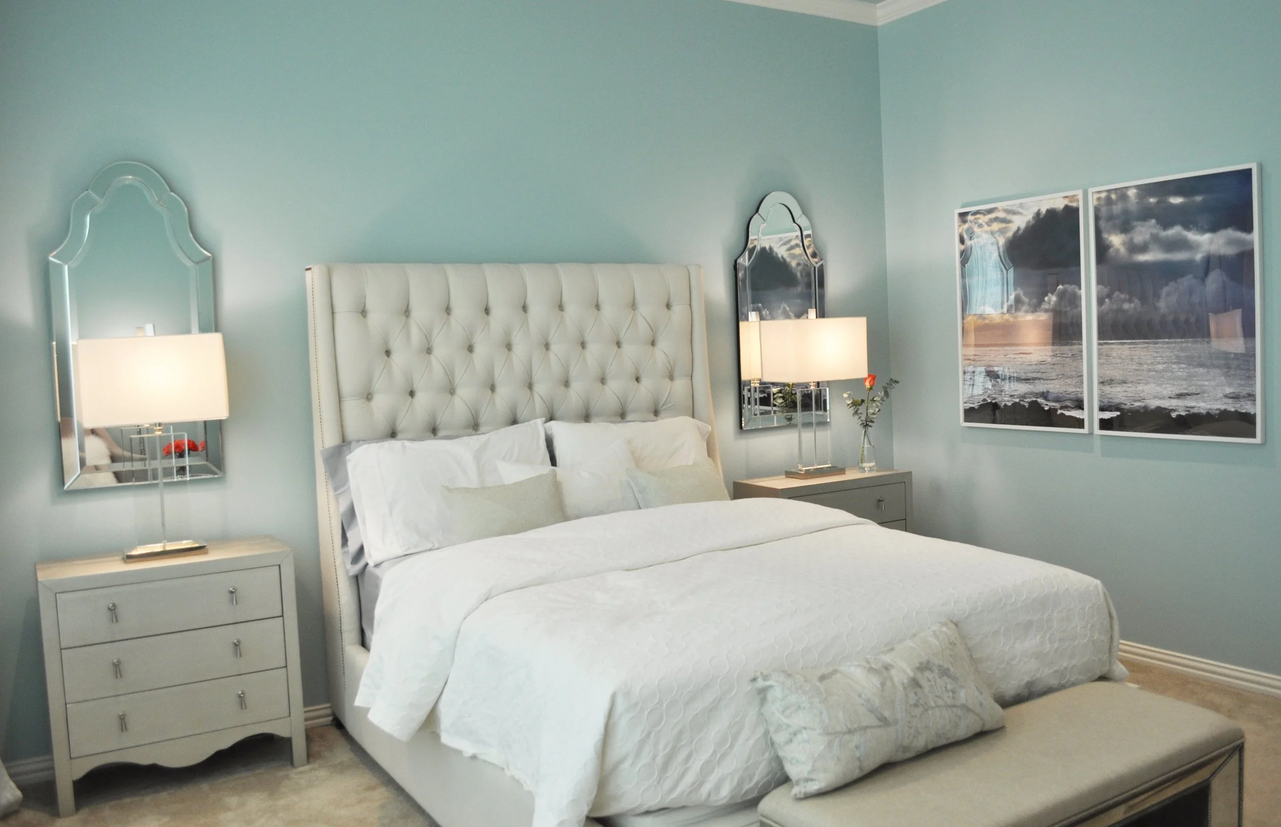Aqua walls and a luxurious upholstered bed with original photography on the walls all designed by Denver interior design firm Jamie House Design.
