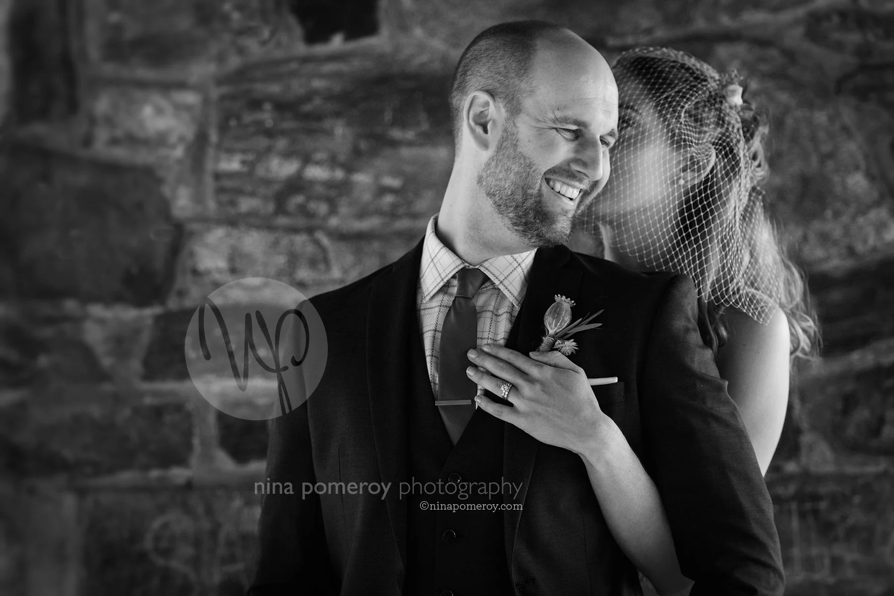 B&W photo of Bride kissing and hugging a smiling groom at a small outdoor garden vineyard wedding by livermore photographer nina pomeroy