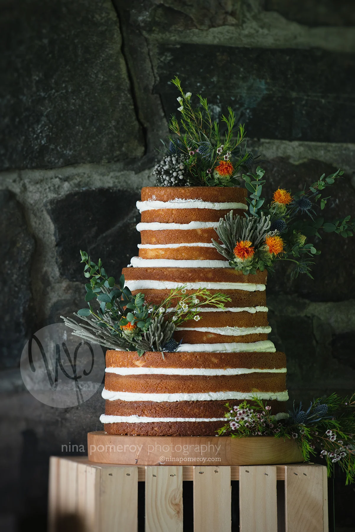 naked un-iced wedding cake embellished with flowers for this beautiful napa garden vineyard wedding taken by photographer nina pomeroy